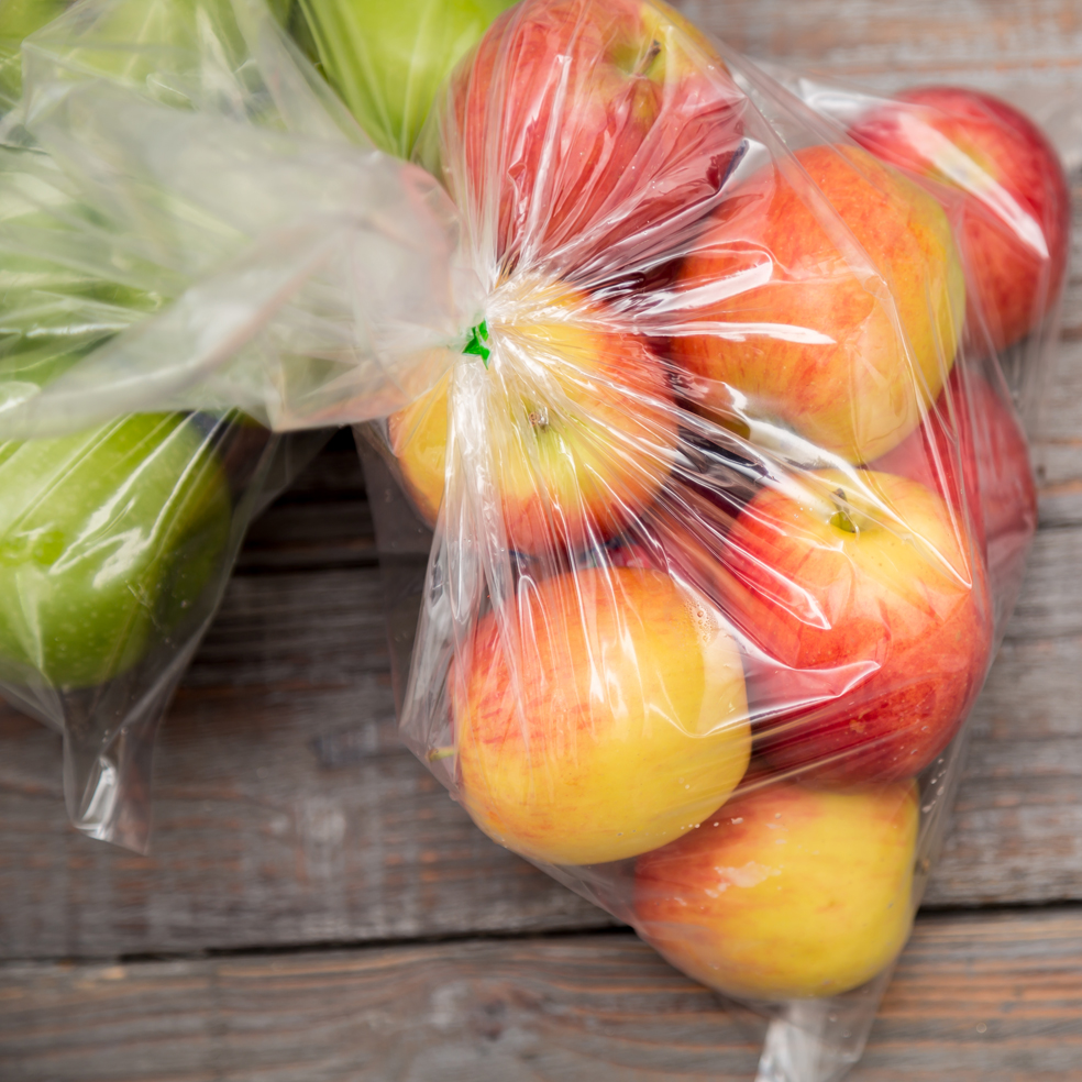 Apple fruit in plastic bag on wood table